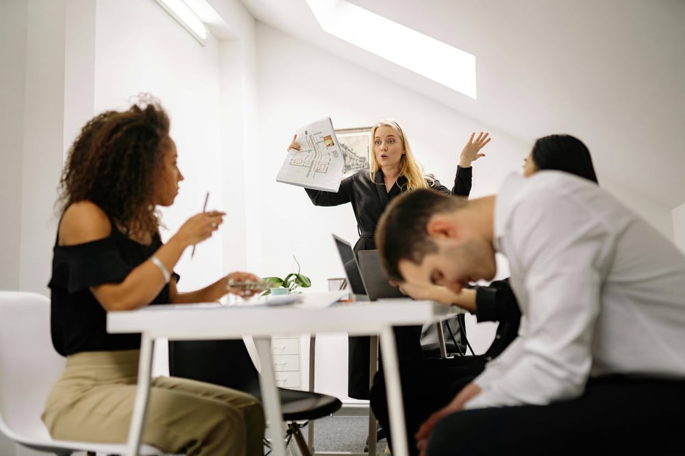 Equipo de trabajo con falta de comunicación durante una reunión por problemas de ego en el trabajo.  