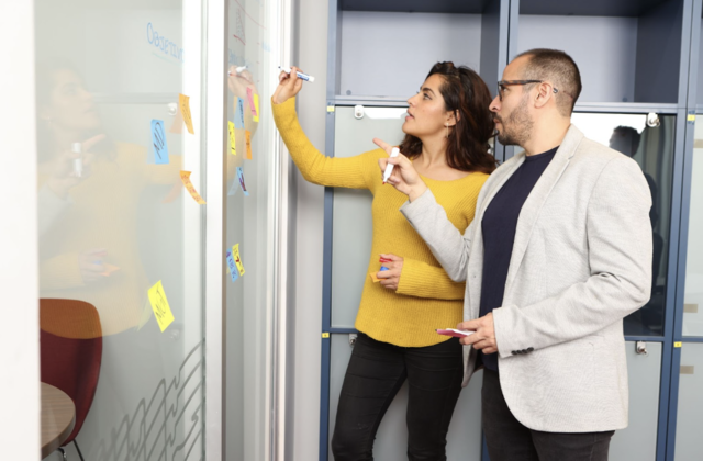 Dos jóvenes planificando diiferentes formas de cooperación entre el sector público y privado